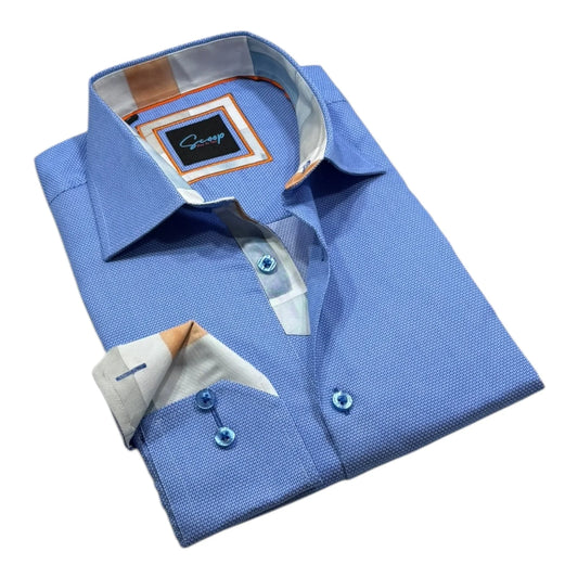 Folded blue dress shirt with a visible brand label on a white background