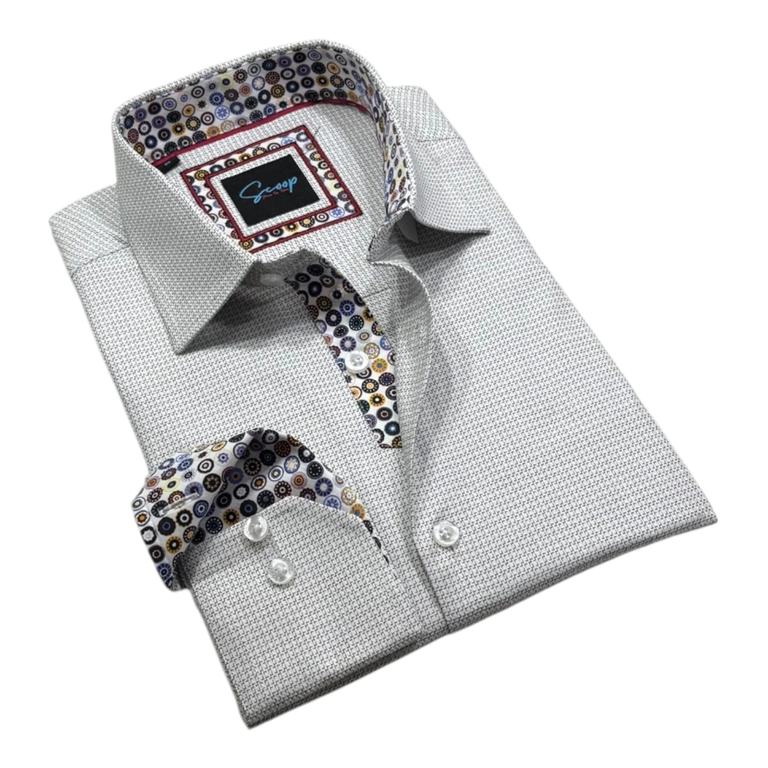 Folded dress shirt with patterned tie and pocket square on a white background