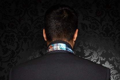 Person wearing a patterned shirt collar against a dark, textured background