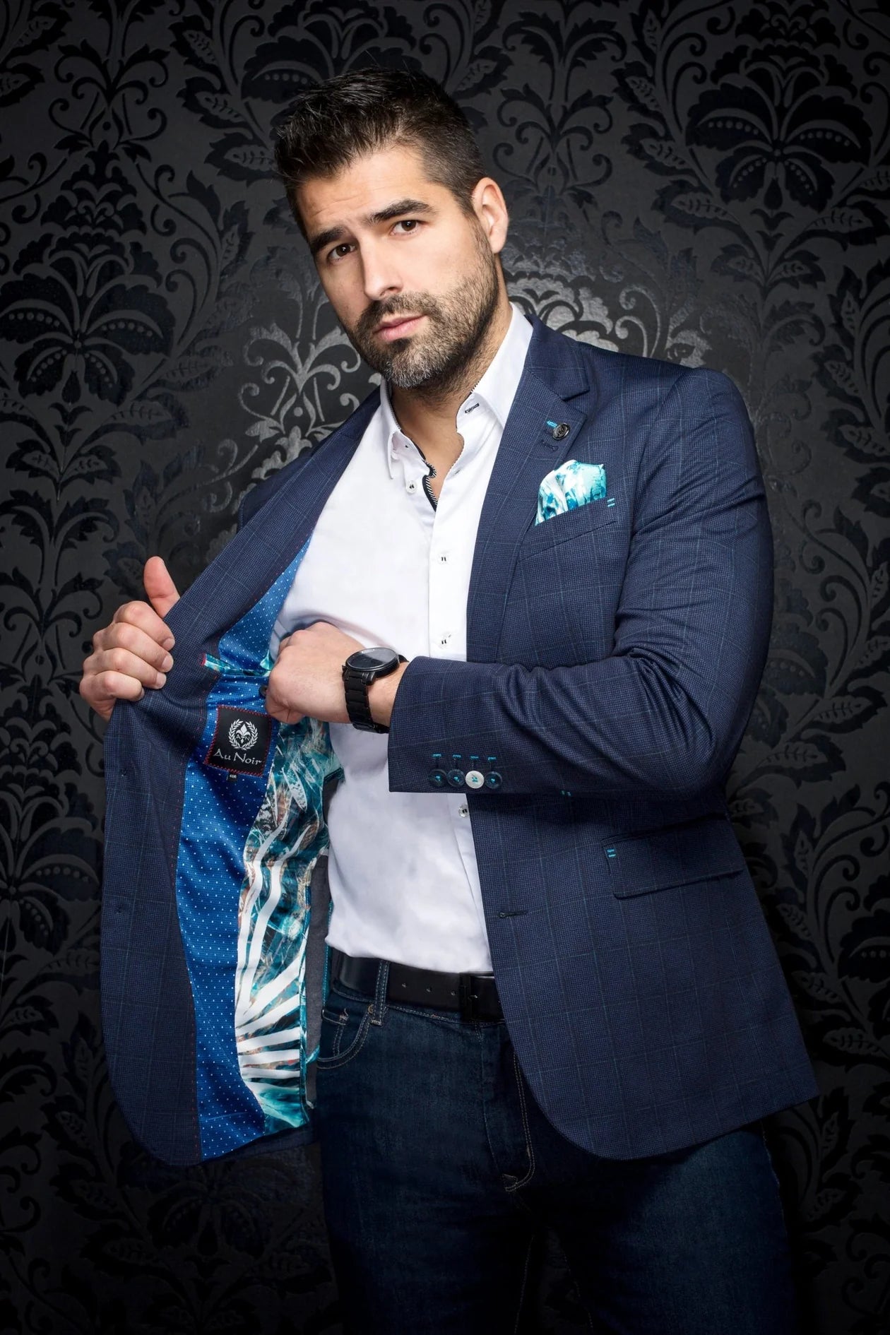 Man holding a sports jersey against a dark patterned background