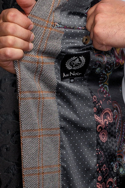 Close-up of a tie with 'Au Noir' label held by hands