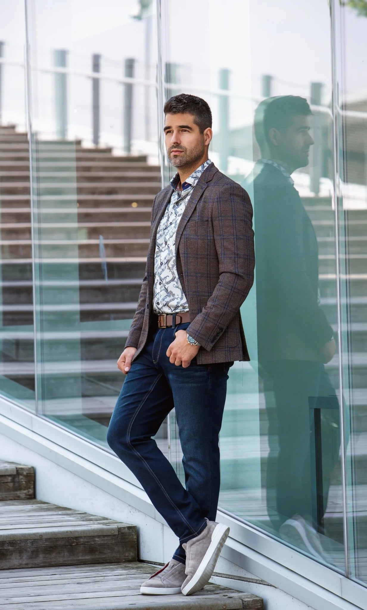 Man in a suit standing on a modern outdoor staircase