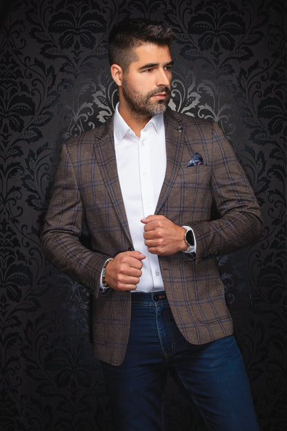 Man wearing a brown checkered blazer over a white shirt with a dark patterned background