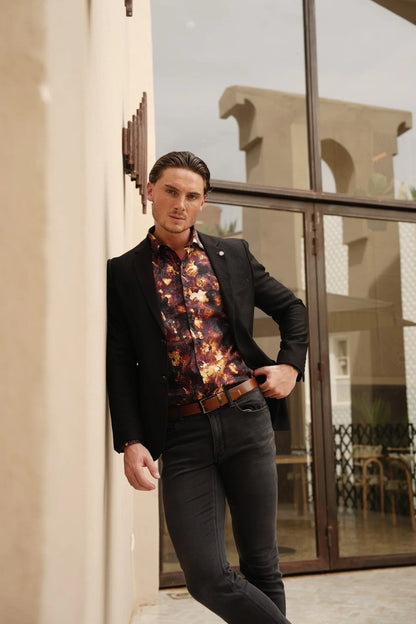 Man in a stylish outfit standing in front of a building entrance.