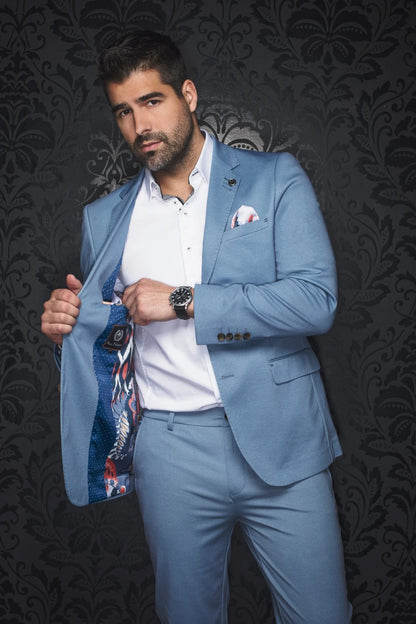 Man wearing a light blue suit with a patterned pocket square against a dark background