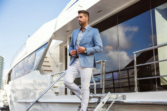 Man in a light blue suit standing on a yacht