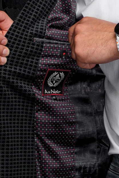 Close-up of a suit with 'Au Noir' label held by a person