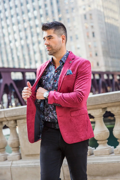 Man wearing a bright pink blazer over a patterned shirt in an urban setting
