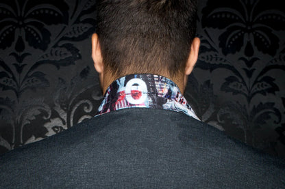 Person wearing a patterned shirt collar with a dark background