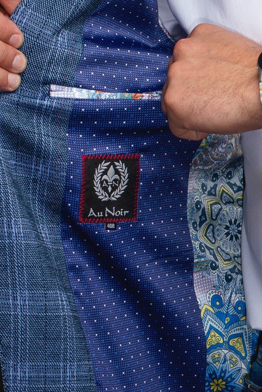 Close-up of a blue patterned suit with a brand label, featuring a colorful tie.