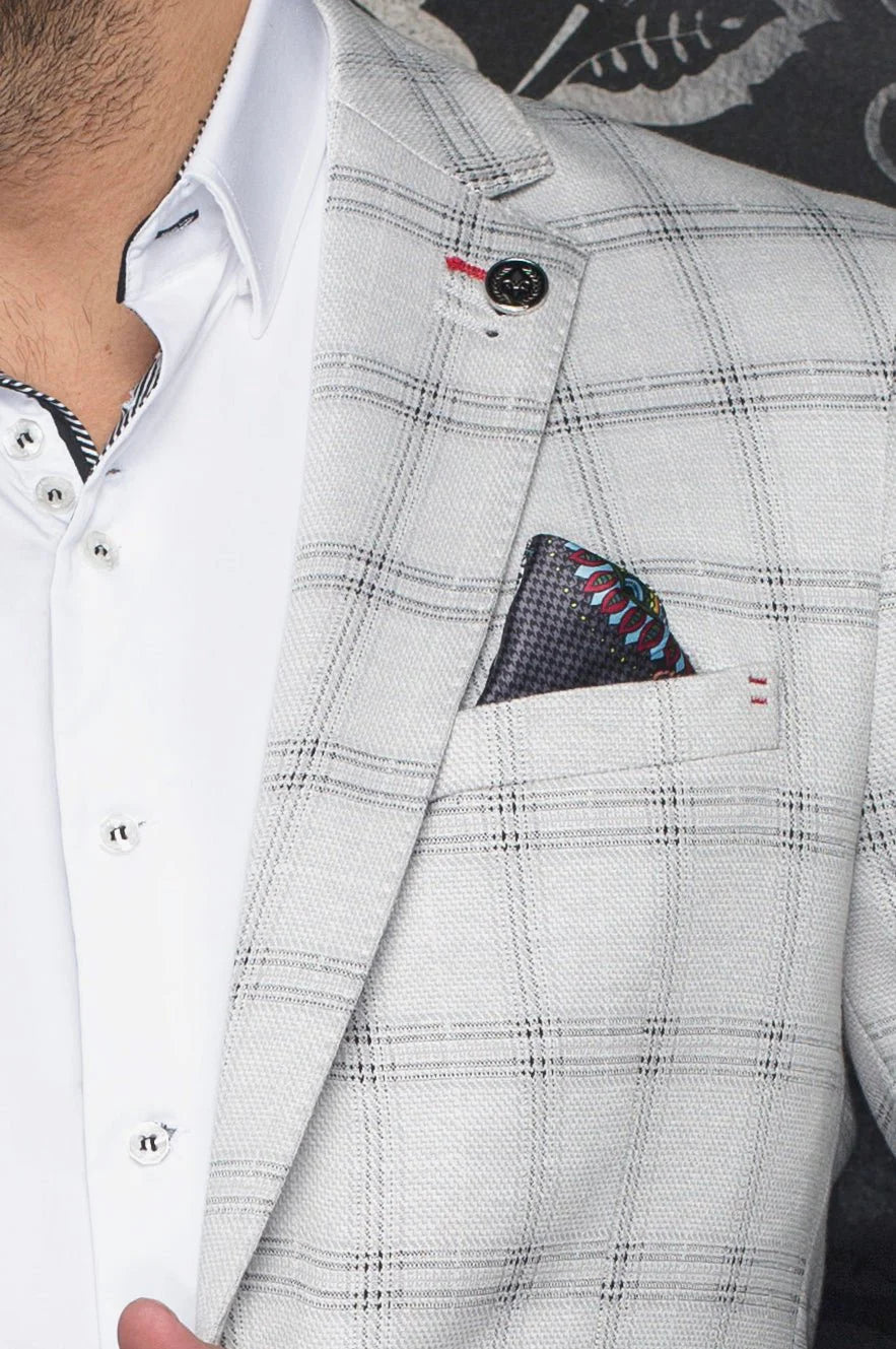 Checkered suit jacket with a patterned pocket square and white shirt.