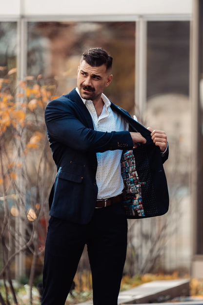 Man holding a patterned bag outdoors with blurred background